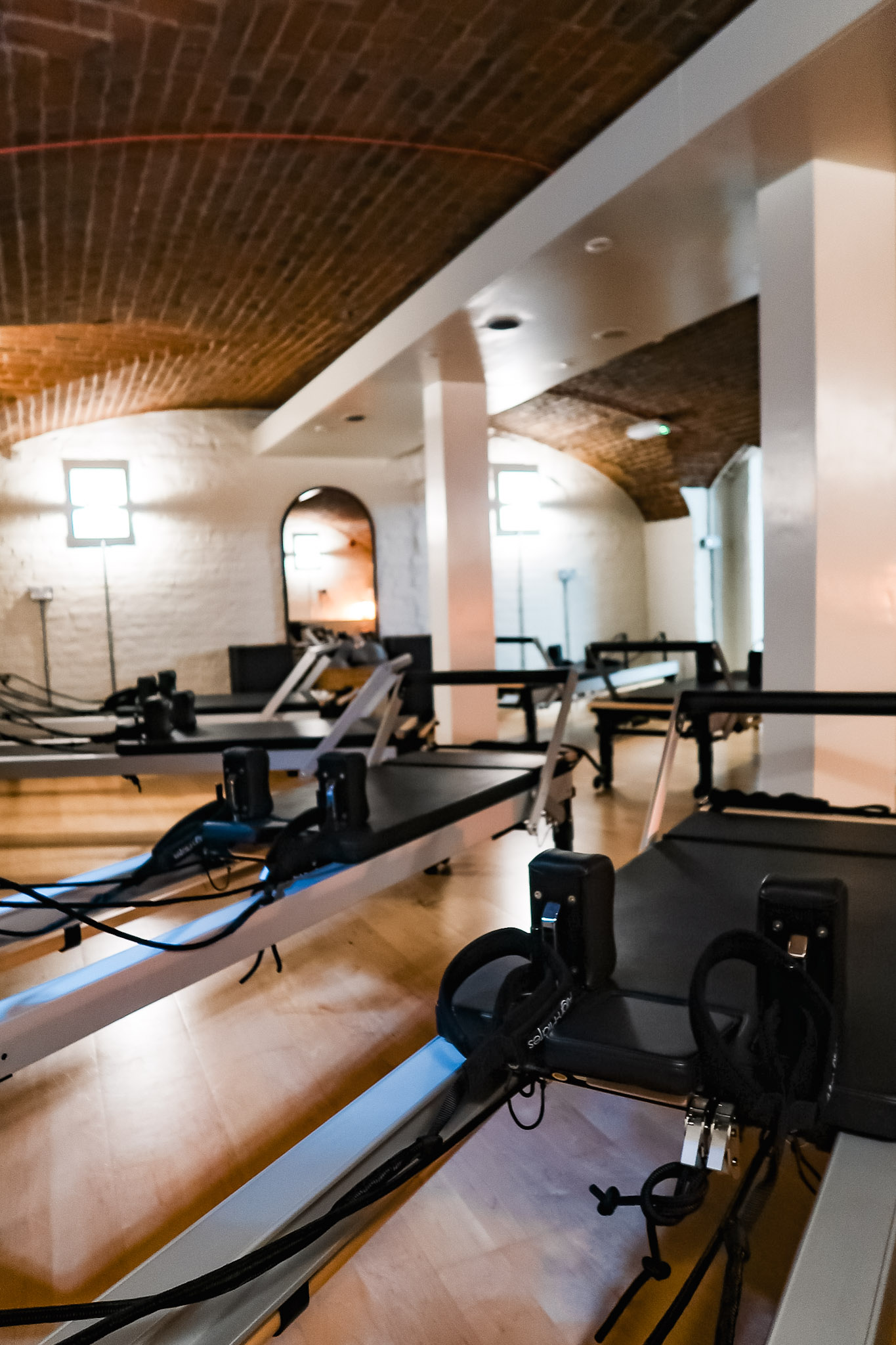 Vaulted basement with wooden floors and reformer pilates machines